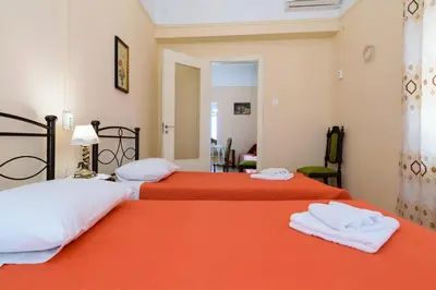 two beds in a room with orange sheets and towels at Chania Vintage Escape - sea view Gem by old port in Chania Town