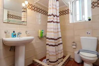 a bathroom with a sink and a toilet and a shower curtain at Chania Vintage Escape - sea view Gem by old port in Chania Town