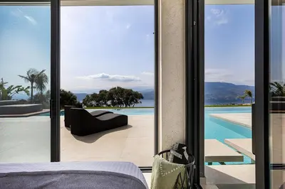 a bedroom with a bed and a view of a pool at Etheria Elli Villa, Retreat to Ethereal Luxury and Wellness by etouri in CHQ