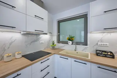 a kitchen with white cabinets and a sink and a window at Galanakis luxury villa in Chania Town