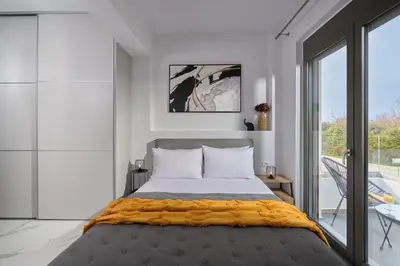 a bedroom with a large bed and a balcony at Galanakis luxury villa in Chania Town