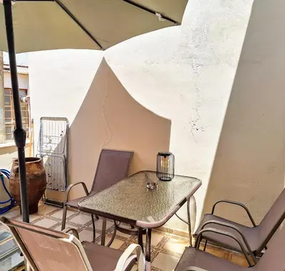 a table and chairs on a balcony with an umbrella at Casa Kadanoleon old town with private terrace in Chania Town