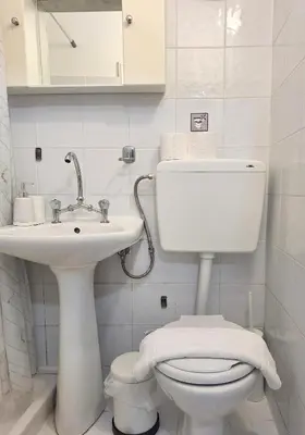 a white bathroom with a toilet and a sink at Casa Kadanoleon old town with private terrace in Chania Town