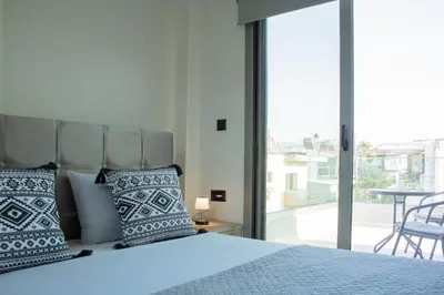 a bedroom with a bed with pillows and a balcony at Welcome U2 in Gerani Chanion