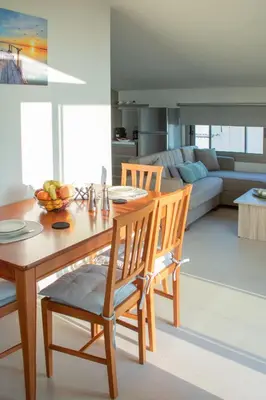 a kitchen and living room with a wooden table and chairs at Welcome U2 in Gerani Chanion