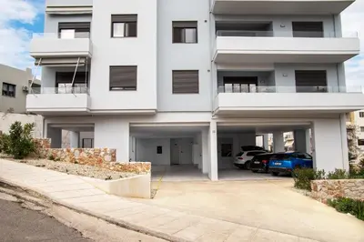 a white apartment building with a parking lot at Stelina Apartment in Chania Town