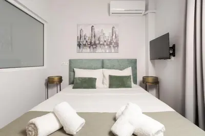a bedroom with a large white bed with two pillows at Zen City Apartment in Chania Town
