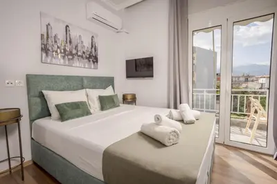 a bedroom with a large bed with a balcony at Zen City Apartment in Chania Town