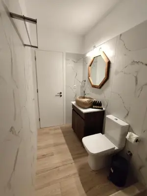 a bathroom with a toilet and a sink and a mirror at Stone Villa Aori in Pemónia