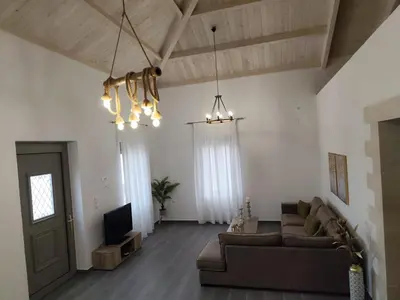 a living room with a couch and a tv at Stone Villa Aori in Pemónia