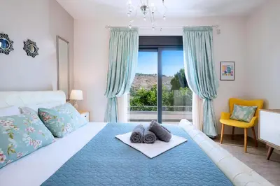 a bedroom with a large bed with a blue rug at Villa Narciso in Souda