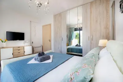 a bedroom with a large white bed with a blue blanket at Villa Narciso in Souda