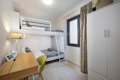 a small bedroom with a desk and a bunk bed at Villa Narciso in Souda