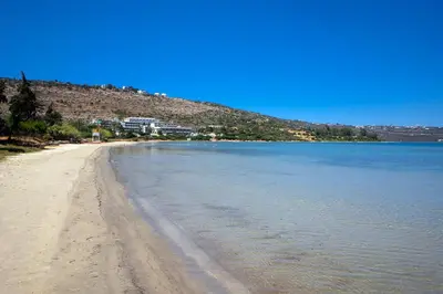 a view of a sandy beach next to the water at Villa Narciso in Souda