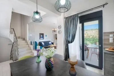 a living room with a table and a staircase at Villa Narciso in Souda