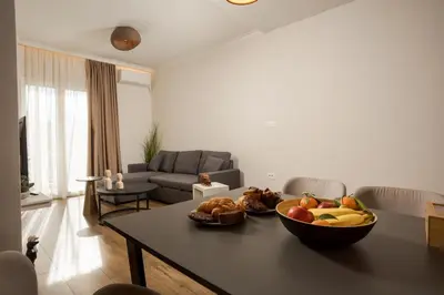 a living room with a table with a bowl of fruit on it at Theni City Apartment by Zen Estate in Chania Town