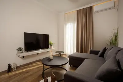 a living room with a couch and a flat screen tv at Theni City Apartment by Zen Estate in Chania Town