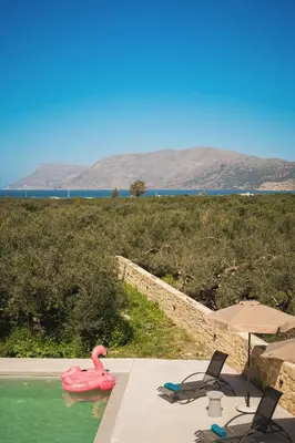 a swimming pool with a pink flamingo in the water at Mythelea Luxury Villa in Kissamos