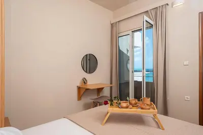 a room with a bed and a table with a window at Cielo Vista in Stalos