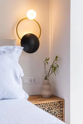 a bedroom with a bed with a lamp and a vase on a table at Fantasea Villas, villa Lumi in Stérnai