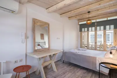 a bedroom with a bed and a mirror and a table at Crescendo Splantzia in Chania Town