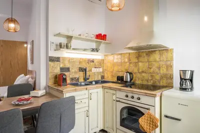 a kitchen with a stove top oven next to a table at Crescendo Splantzia in Chania Town