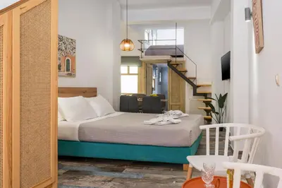 a small room with a bed and a table and chairs at Crescendo Splantzia in Chania Town