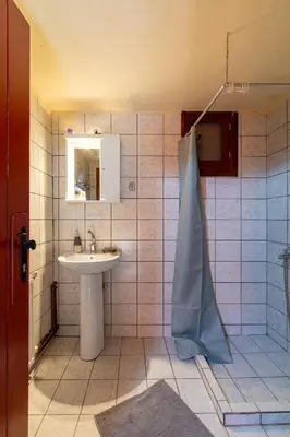 a bathroom with a sink and a mirror and a shower at Vavouledo Village House in Khamalévri