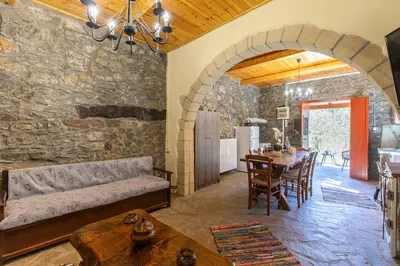 a living room with a couch and a table at Vavouledo Village House in Khamalévri