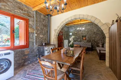 a kitchen and dining room with a wooden table at Vavouledo Village House in Khamalévri
