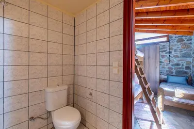 a bathroom with a toilet and a ladder in a room at Vavouledo Village House in Khamalévri