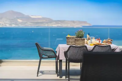 a table with chairs and a table with a view of the ocean at Villa Orama - Sea view with private pool in Kalyves