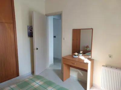 a bedroom with a wooden desk and a mirror at Beachfront apartment in Daratso