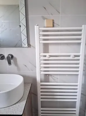 a white bathroom with a sink and a mirror at Beachfront apartment in Daratso