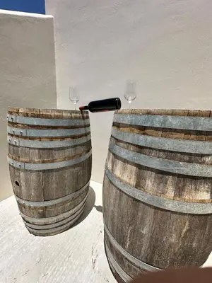 two wooden barrels with wine glasses in them at Melina's house in Skinés