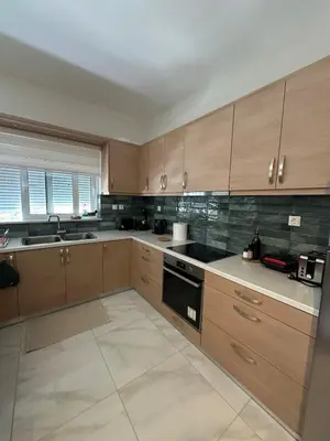 a large kitchen with wooden cabinets and appliances at Melina's house in Skinés