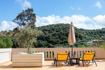 a patio with two chairs and an umbrella at Lucia's Home in Stalos