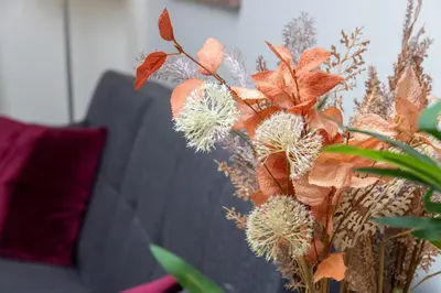 a vase filled with flowers next to a couch at Lucia's Home in Stalos