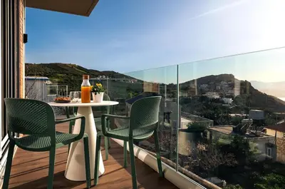 a balcony with a table and chairs and a view at Raviewha Luxury Apartments 2 in Ravdhoúkha