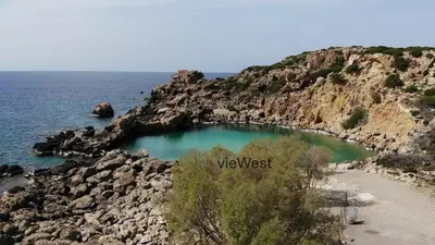 a small pool of water on a rocky beach at View West Elafonisi house in Livadia