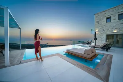 a woman standing next to a swimming pool in a house at Nafsika Xenia - Odysseus in Falasarna