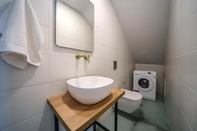 a bathroom with a sink and a washing machine at Nafsika Xenia - Odysseus in Falasarna
