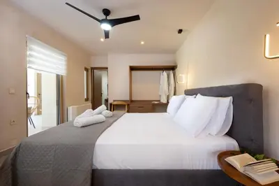a bedroom with a large bed with white sheets and pillows at Villa George in Límni