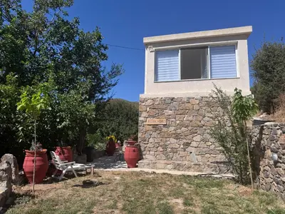 a house with a stone wall and a window at Petra Homes Temenia in Teménia