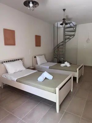 two beds sitting next to each other in a room at Petra Homes Temenia in Teménia