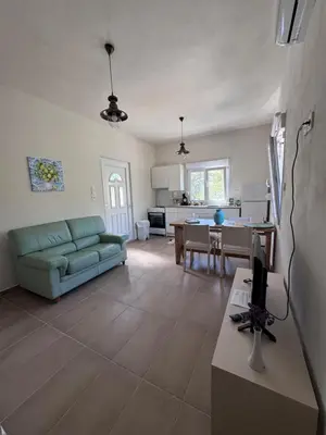 a living room with a green couch and a kitchen at Petra Homes Temenia in Teménia