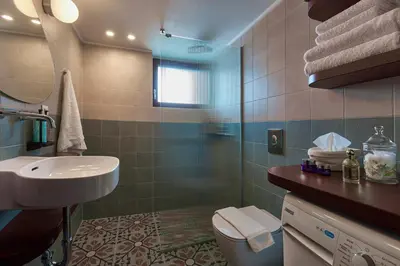 a bathroom with a sink and a toilet and a shower at Katsambas Apartment - Cozy Retro-Luxury with Balcony in Chania Town