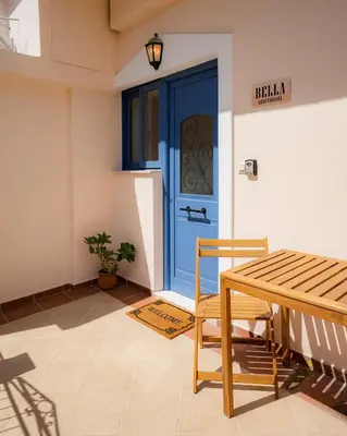 a blue door with a table and a chair at Bella Apartment in Chania Town