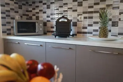 a kitchen with a microwave and a bowl of fruit at Tzei House - 5min drive to beach in Perivólia