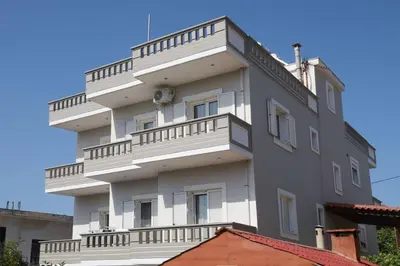 a tall white building with balconies on it at Tzei House - 5min drive to beach in Perivólia